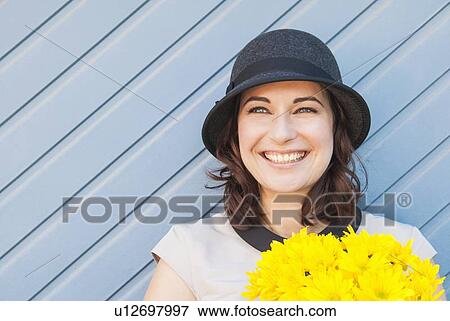 Stock Photo - Woman leaning on wooden wall outdoors. Fotosearch