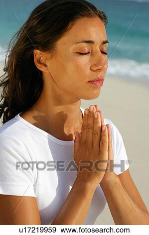 Stock Photo - Woman meditating on beach. Fotosearch