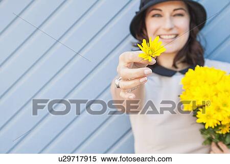 Woman offering yellow flower outdoors View Large Photo Image Stock Photography - Woman offering yellow flower outdoors. Fotosearch