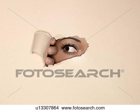 Picture - Woman peeking through hole in wall. Fotosearch