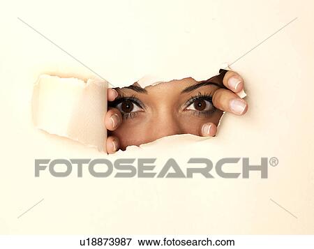 Stock Photo - Woman peeking through hole in wall. Fotosearch