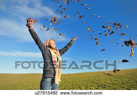 Woman playing in autumn leaves View Large Photo Image Stock Image - Woman playing in autumn leaves. Fotosearch