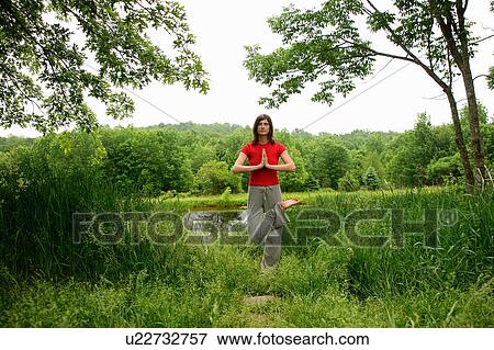 Woman practicing yoga by rural lake View Large Photo Image Stock Photo - Woman practicing yoga by rural lake. Fotosearch