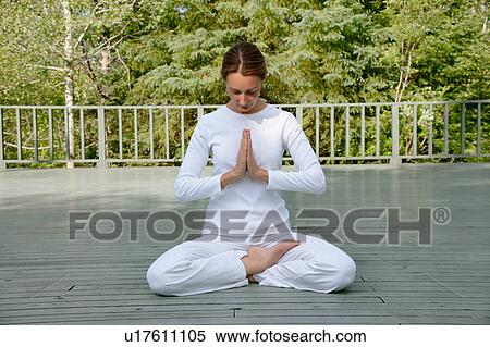 Stock Photography - Woman practicing yoga outdoors. Fotosearch