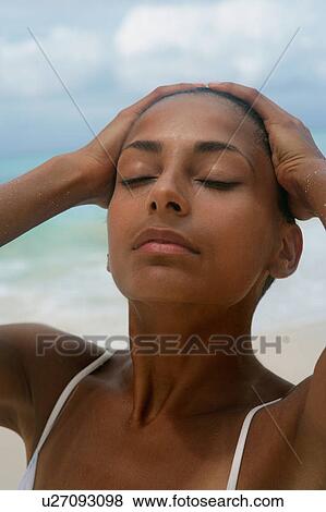Stock Photo - Woman pushing her hair back outdoors. Fotosearch