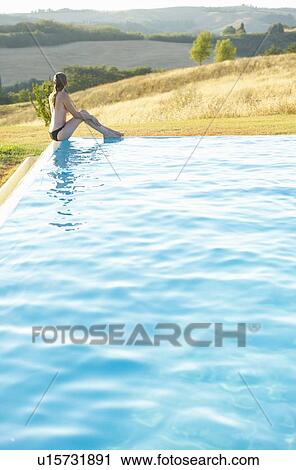 Woman sitting at edge of pool View Large Photo Image Stock Image - Woman sitting at edge of pool. Fotosearch