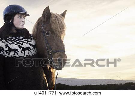 Stock Image - Woman smiling with horse outdoors. Fotosearch