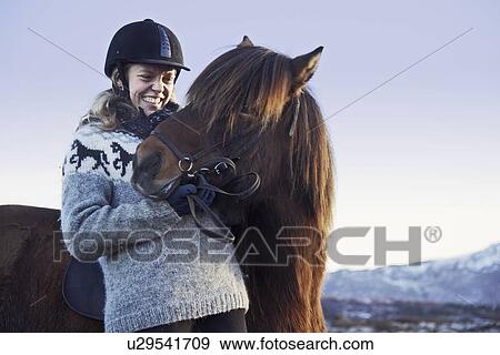 Stock Photo - Woman smiling with horse outdoors. Fotosearch