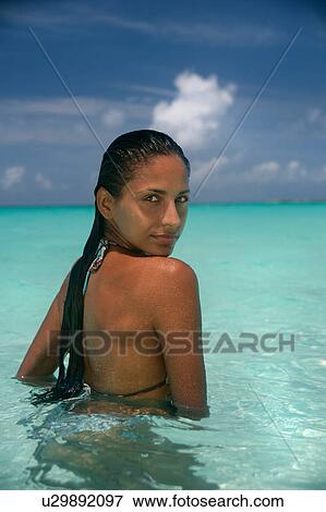 Stock Photo - Woman standing in tropical water. Fotosearch