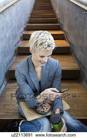 Woman using cell phone on lunch break View Large Photo Image Stock Image - Woman using cell phone on lunch break. Fotosearch