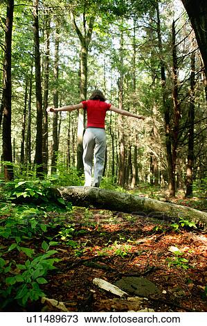 Stock Image - Woman walking in forest. Fotosearch