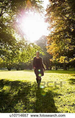 Stock Photo - Woman walking in park. Fotosearch