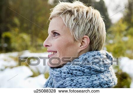 Stock Photo - Woman wearing knitted scarf outdoors. Fotosearch