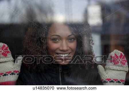 Woman wearing mittens at window View Large Photo Image Stock Image - Woman wearing mittens at window. Fotosearch