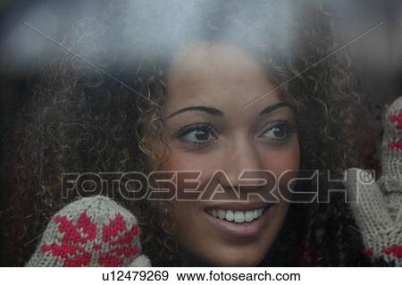 Stock Photo - Woman wearing mittens at window. Fotosearch