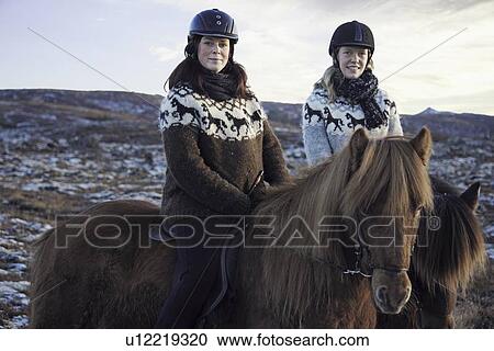 Stock Image - Women riding horses outdoors. Fotosearch