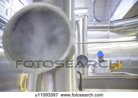 Worker examining smoked fish in factory View Large Photo Image Stock Photo - Worker examining smoked fish in factory. Fotosearch