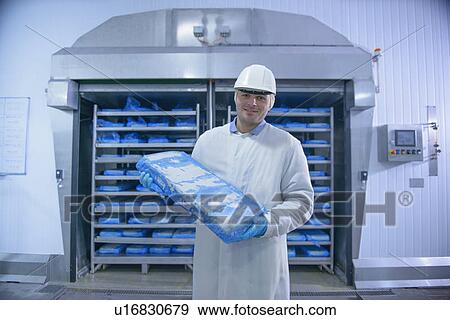 Worker holding packed fish in factory View Large Photo Image Stock Photo - Worker holding packed fish in factory. Fotosearch