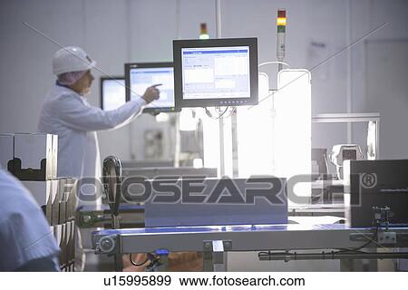 Stock Photo - Workers weighing product in factory. Fotosearch