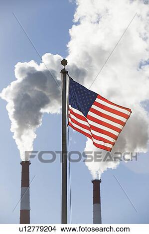 American flag in front of smoke stacks View Large Photo Image Picture - American flag in front of smoke stacks . Fotosearch