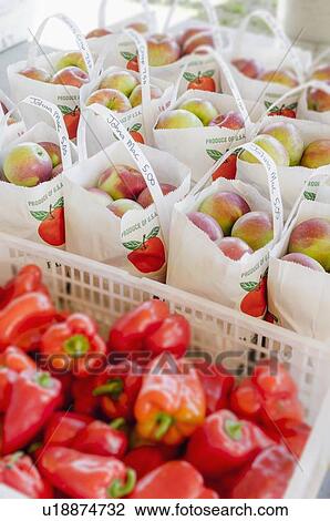 Stock Image - Apples and red peppers ready to be bought. Fotosearch
