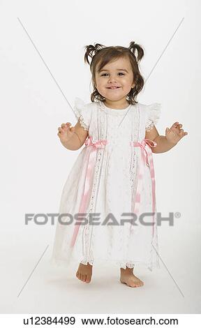 Stock Photo - Baby girl ( 6-11 months) wearing white dress. Fotosearch