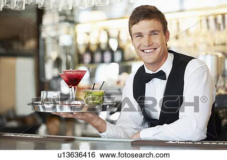 Bartender holding tray with cocktails View Large Photo Image Stock Photograph - Bartender holding tray with cocktails. Fotosearch