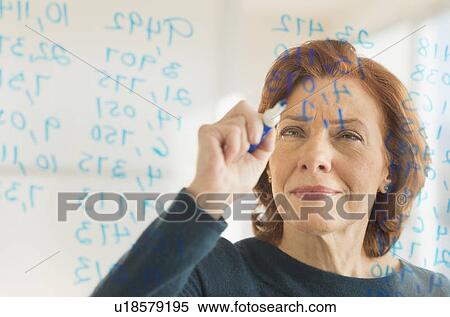 Stock Photography - Businesswoman writing on transparent board. Fotosearch