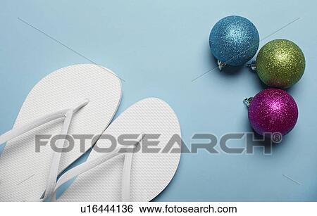 Christmas decorations and pair of flip-flops on blue background View Large Photo Image Stock Photograph - Christmas decorations and pair of flip-flops on blue background. Fotosearch