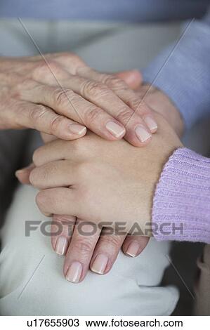Stock Image - Close-up of hands of grandmother and granddaughter (16-17). Fotosearch