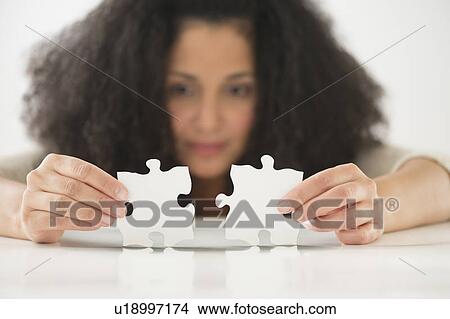 Close up of woman's hands matching jigsaw puzzle View Large Photo Image Picture - Close up of woman's hands matching jigsaw puzzle. Fotosearch