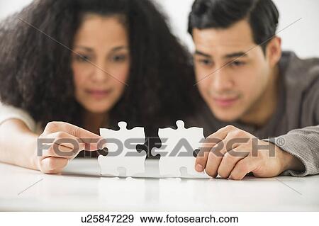 Couple matching jigsaw puzzle View Large Photo Image Stock Photo - Couple matching jigsaw puzzle. Fotosearch