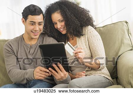 Couple using digital tablet on sofa View Large Photo Image Stock Photography - Couple using digital tablet on sofa. Fotosearch