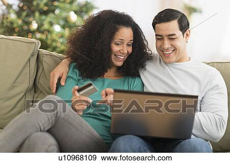Couple using laptop for online shopping View Large Photo Image Stock Photo - Couple using laptop for online shopping. Fotosearch