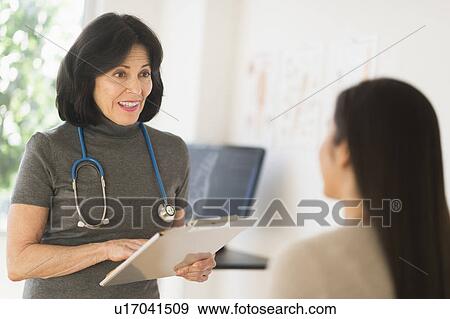 Stock Photo - Doctor talking to teenage girl (16-17). Fotosearch