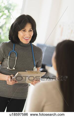 Stock Photograph - Doctor talking to teenage girl (16-17). Fotosearch