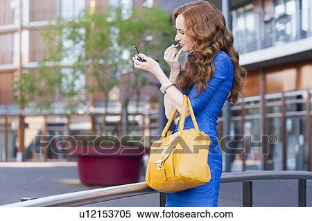 Elegant woman improving her make-up View Large Photo Image Stock Photography - Elegant woman improving her make-up. Fotosearch