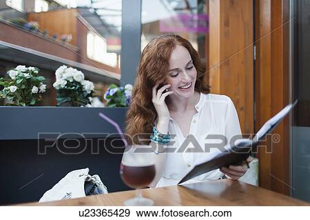 Stock Photo - Elegant woman in cafe using mobile phone. Fotosearch