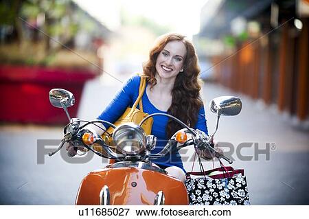 Stock Photo - Elegant woman on motorcycle. Fotosearch