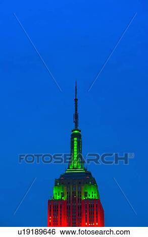 Stock Photograph - Empire State Building illuminated in red and green. Fotosearch