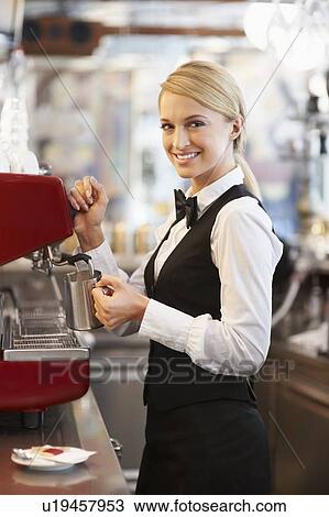 Stock Image - Female barista steaming milk. Fotosearch