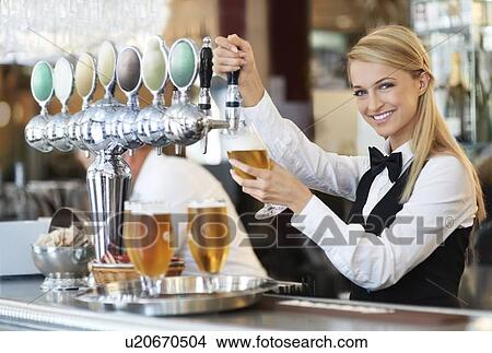 Picture - Female bartender pouring beer. Fotosearch