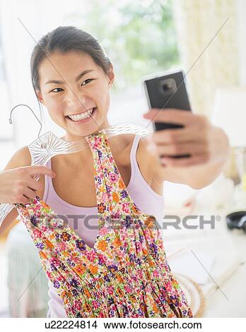Front view of teenage girl ( 16-17 years) taking photo of herself View Large Photo Image Picture - Front view of teenage girl ( 16-17 years) taking photo of herself. Fotosearch