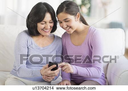 Grandmother and granddaughter (16-17) with mobile phone View Large Photo Image Picture - Grandmother and granddaughter (16-17) with mobile phone. Fotosearch