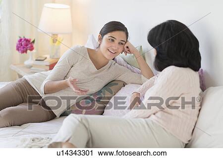 Stock Image - Grandmother and granddaughter (16-17) talking. Fotosearch