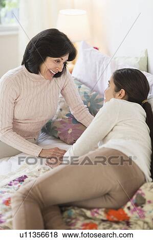 Stock Photo - Grandmother and granddaughter (16-17) talking. Fotosearch