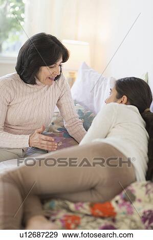 Stock Photo - Grandmother and granddaughter (16-17) talking. Fotosearch