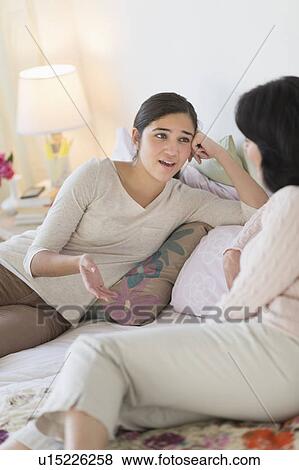 Stock Photo - Grandmother and granddaughter (16-17) talking. Fotosearch