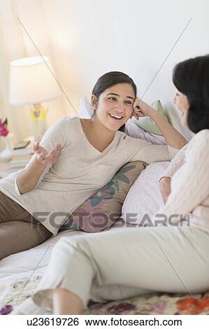 Stock Photograph - Grandmother and granddaughter (16-17) talking. Fotosearch