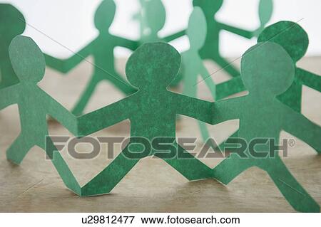 Stock Photo - Human silhouettes cut out from green paper. Fotosearch